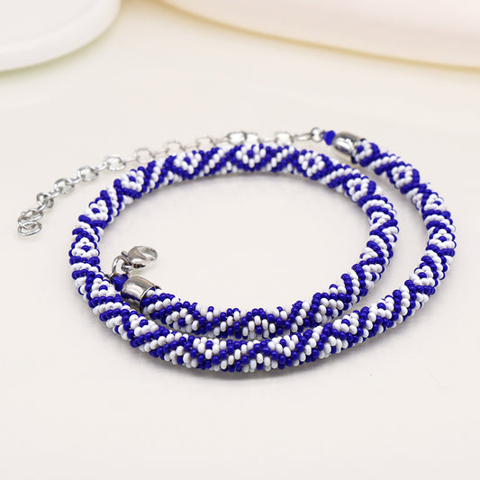 Blue and white bead necklace with a spiral pattern resembling a snake design, featuring a silver clasp and extender chain.