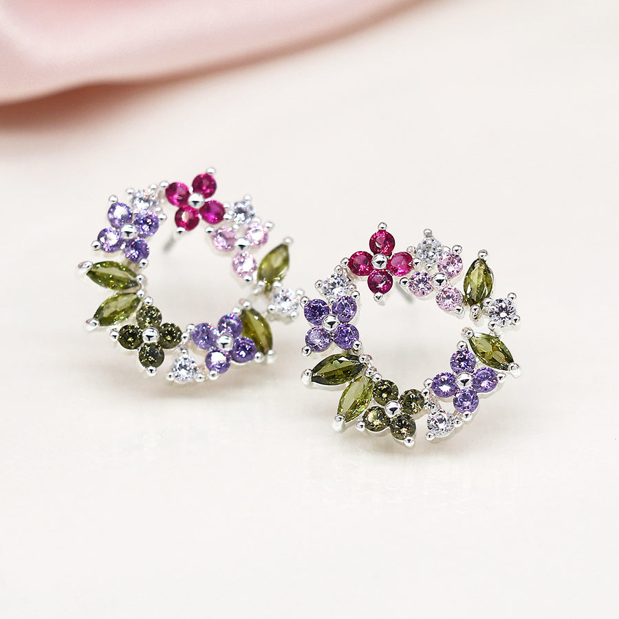 Floral Circle Studs with colourful wreath designs, featuring pink, purple, and green gemstones set in faceted crystals. These silver-plated earrings gleam beautifully against a white background.