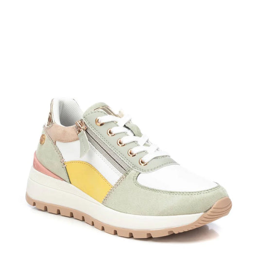A stylish vegan trainer featuring white, beige, yellow, and light green panels, white laces, a side zip, and a non-slip rubber sole for added grip, set against a white background.