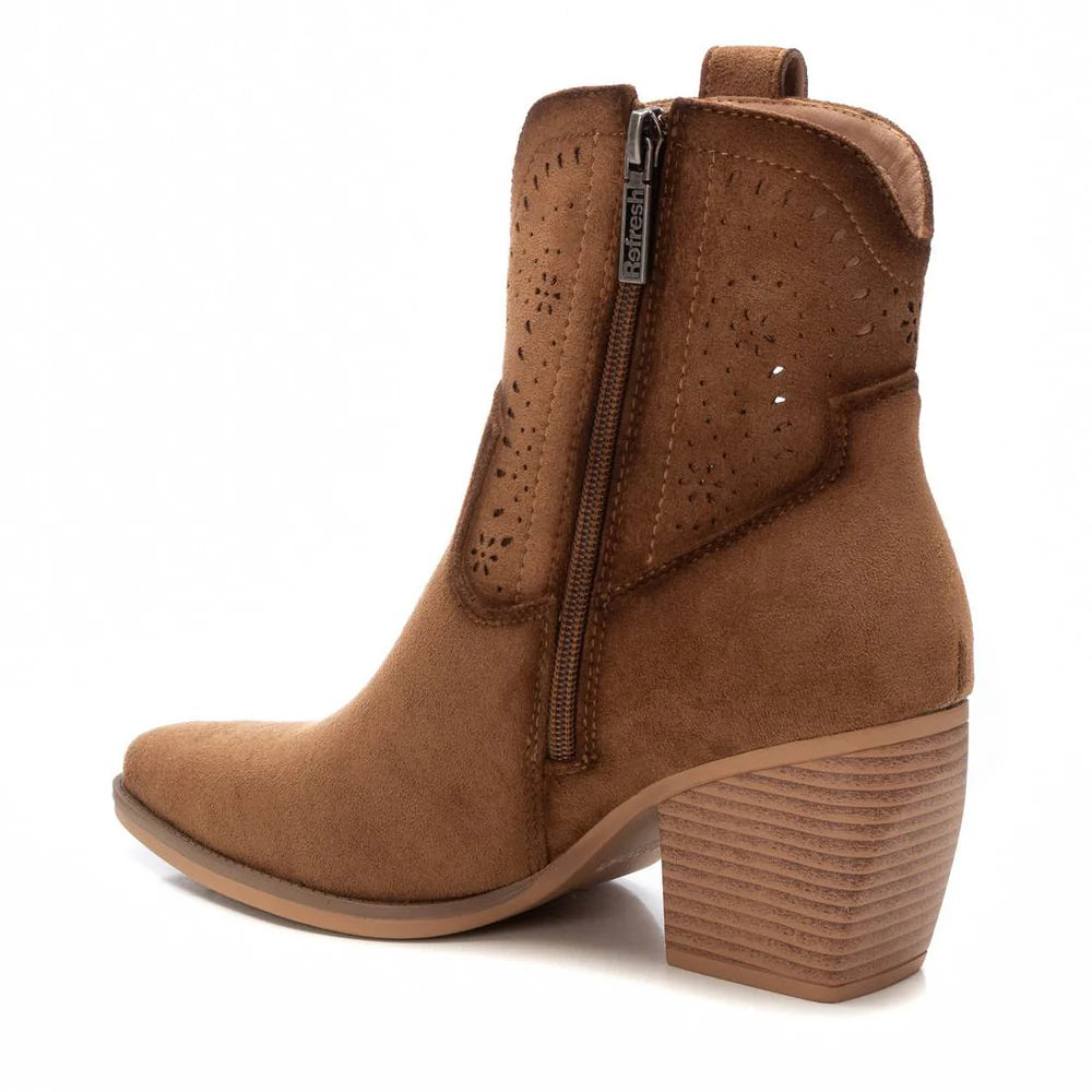 A brown suede cowboy ankle boot with a stacked heel, elegant interior zip fastening, and perforated detailing near the top.