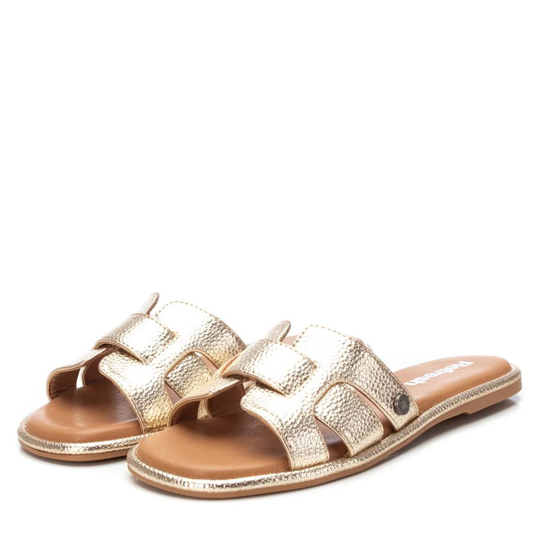 A pair of gold womens sandals with textured straps and flat soles, crafted from premium leather, displayed against a white background. Rewritten in British English: A pair of gold ladies’ sandals with textured straps and flat soles, crafted from premium leather, shown against a white background.
