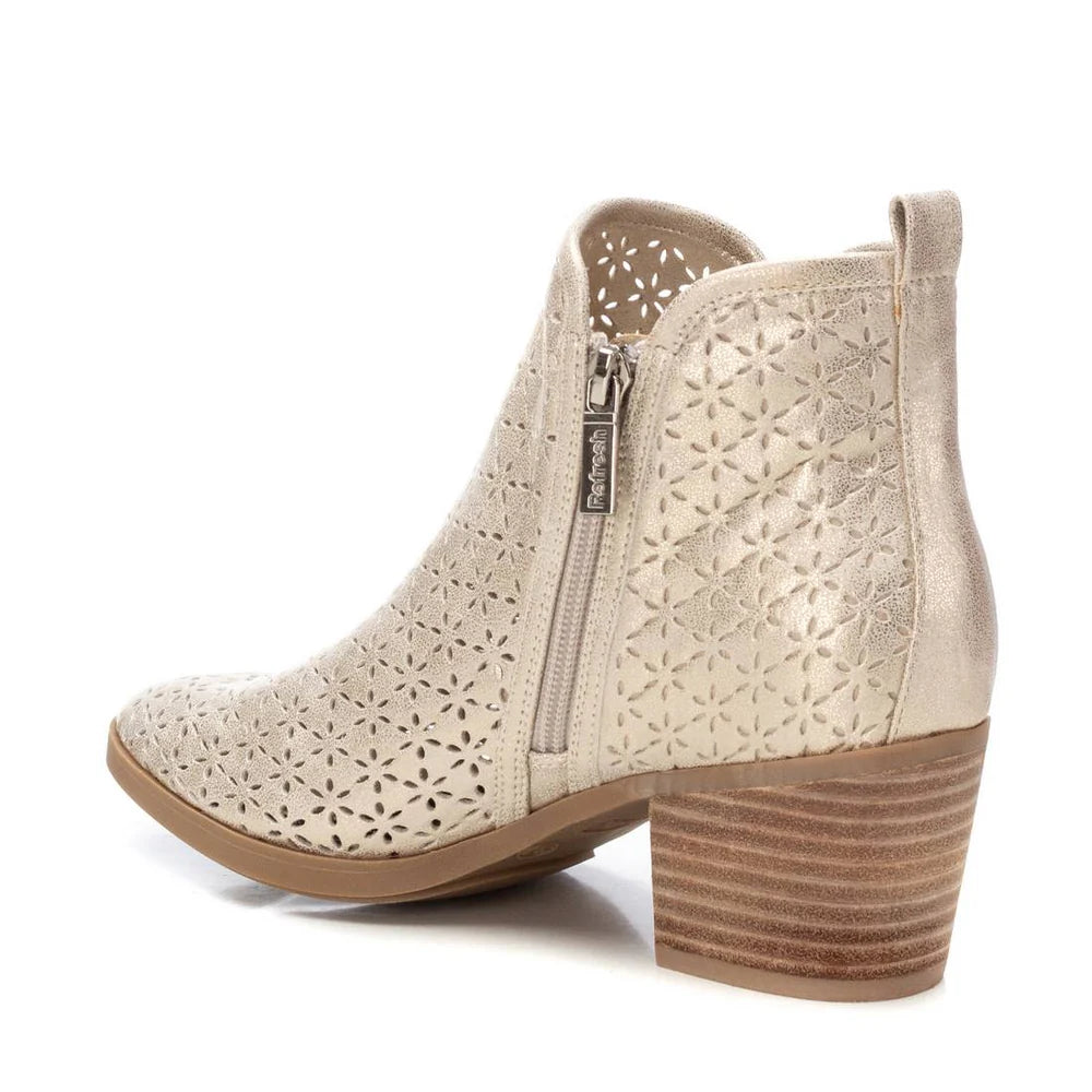 Side view of a Refresh Ankle Boot in beige with a stacked heel, decorative perforated floral pattern, inner zip fastening, and pull tab at the back.