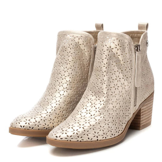 A pair of pale gold ankle boots featuring laser-cut floral patterns, side zips, pull tabs, and stacked block heels for a chic look.