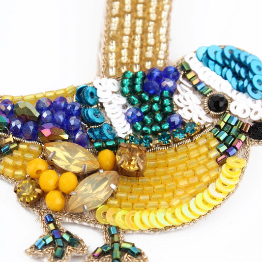 This handcrafted beaded bird brooch from India features intricate beadwork with yellow, blue, green, and white beads, providing exquisite detailing and a stunning three-dimensional effect.