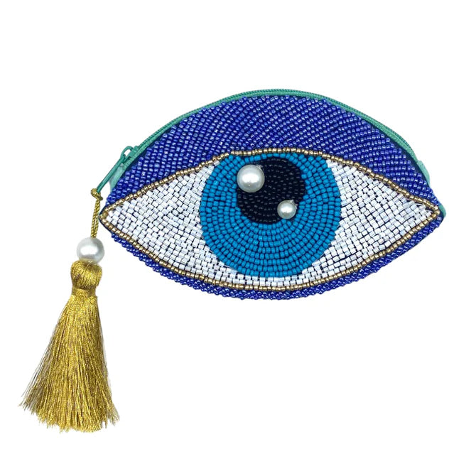 The Glimmer Eye Purse is a vegan-friendly beaded clutch in the shape of an eye, featuring blue, white and black beads, two pearl accents, and a gold tassel on the zip.