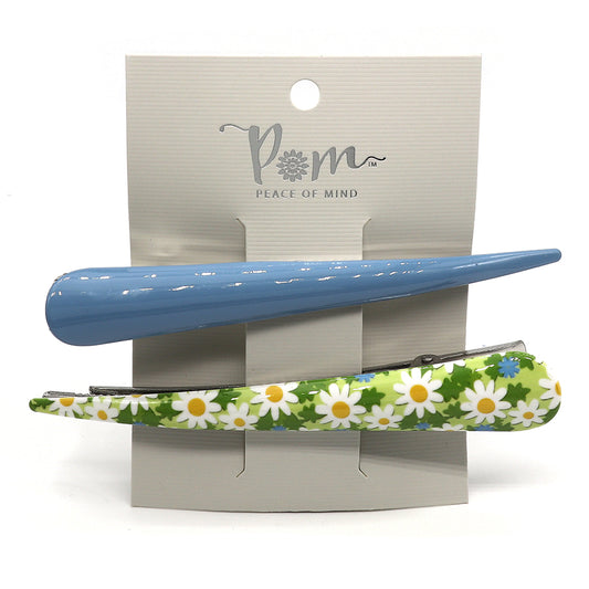 Introducing our premium clip duo: one solid blue clip and another adorned with a daisy pattern on a green background, both elegantly presented on a display card. Perfect for adding a touch of charm to any hairstyle!.