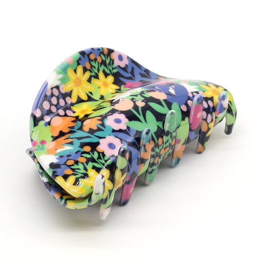 A large, luxurious hair accessory, this black multi-floral mix claw clip features a colourful floral pattern with bright flowers and green leaves on a white background. Crafted from premium acrylic for lasting elegance.