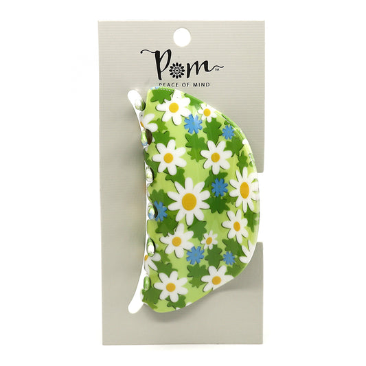 A green floral hair claw featuring white and blue flower designs is attached to a beige card labelled Pom Peace of Mind, crafted from durable acrylic for a luxurious accessory.