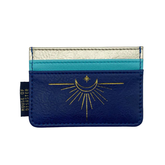 Blue, turquoise, and silver card holder with a gold celestial motif showing a crescent moon and star. This cruelty-free, vegan purse bears a House of Disaster label on the left-hand side.