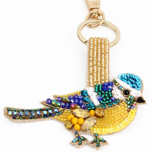This beaded Blue Tit keyring showcases vibrant colours—blue, yellow, green, and gold. Handcrafted in India, it features intricate beadwork with sequins and a gold keyring and clip.