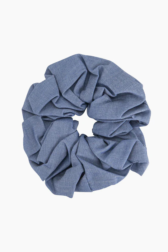 The Dakota Large Blue Denim Look Scrunchie, crafted from high-quality denim fabric, features a textured surface perfect for a sophisticated hairdo.