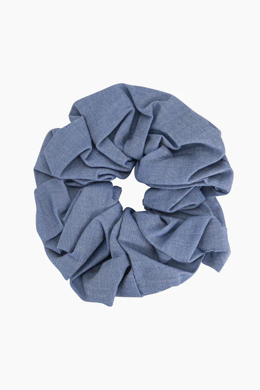 The Dakota Large Blue Denim Look Scrunchie, crafted from high-quality denim fabric, features a textured surface perfect for a sophisticated hairdo.