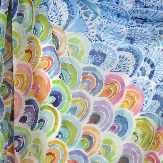 Close-up of a fashion-forward accessory: vibrant fabric with a pattern resembling peacock feathers, showcasing a watercolour rainbow print in shades of blue, green, pink, orange, and yellow.