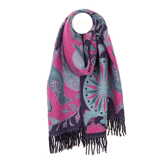 A pink and blue patterned scarf with floral and peacock motifs, featuring fringed ends, hangs on a round, white hook. This luxurious accessory showcases a stunning jacquard design perfect for any outfit.
