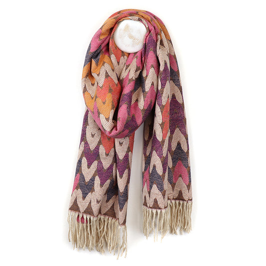 Reversible Warm Mix Heart Scarf in vibrant Jacquard fabric, featuring pink, orange, brown, and beige hearts with a stylish fringe. Draped elegantly on a white hanger, this piece embodies eco-consciousness while adding flair to any outfit.