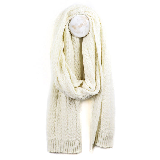 A cosy knitted scarf in cream, made from recycled vegan yarn, hangs on a white wall hook against a plain white background.