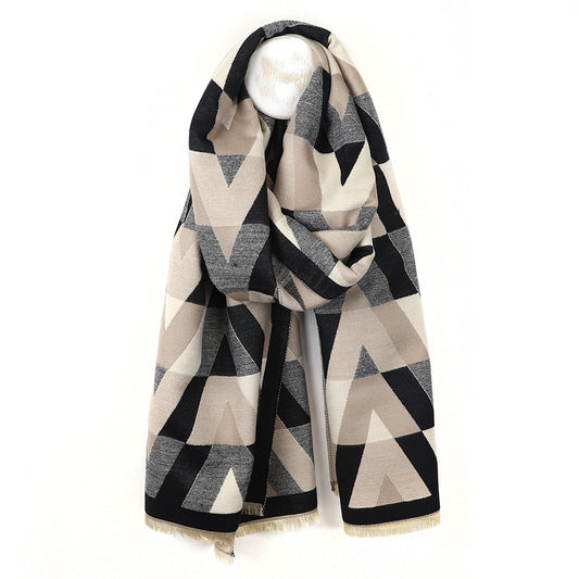 A stylish chevron scarf featuring a geometric pattern in black, beige, and grey tones is draped around a white rounded display stand set against a plain background.