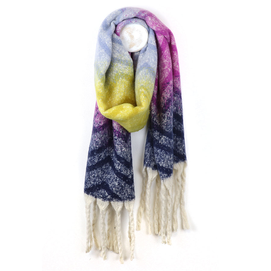 A colourful accessory, this Ombre Bouclé Chevron Scarf boasts a gradient of blue, yellow, and purple with a geometric pattern and white fringed ends.