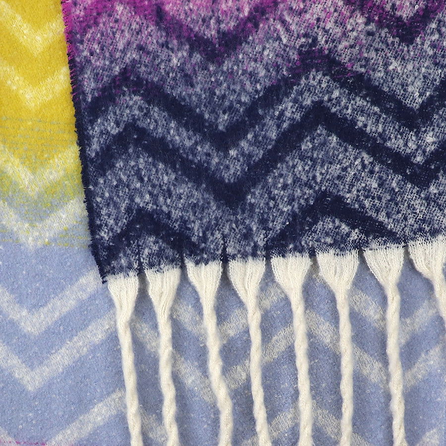 Close-up of an Ombre Bouclé Chevron Scarf showcasing a chevron pattern in navy, purple, yellow, and white with fringed white tassels—a cosy scarf and stylish colourful accessory.