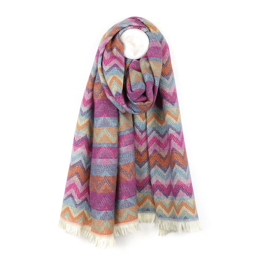 A vibrant fashion accessory, this colourful chevron scarf boasts a zigzag pattern in shades of pink, orange, blue and purple, finished with short white fringe at both ends.