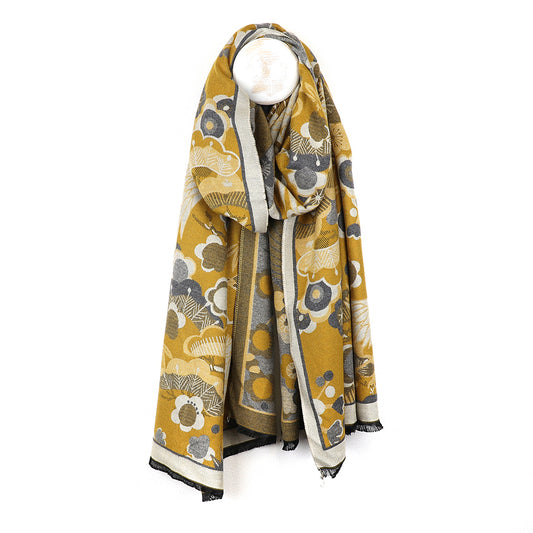A fashionable mustard scarf showcased gracefully on a mannequin.