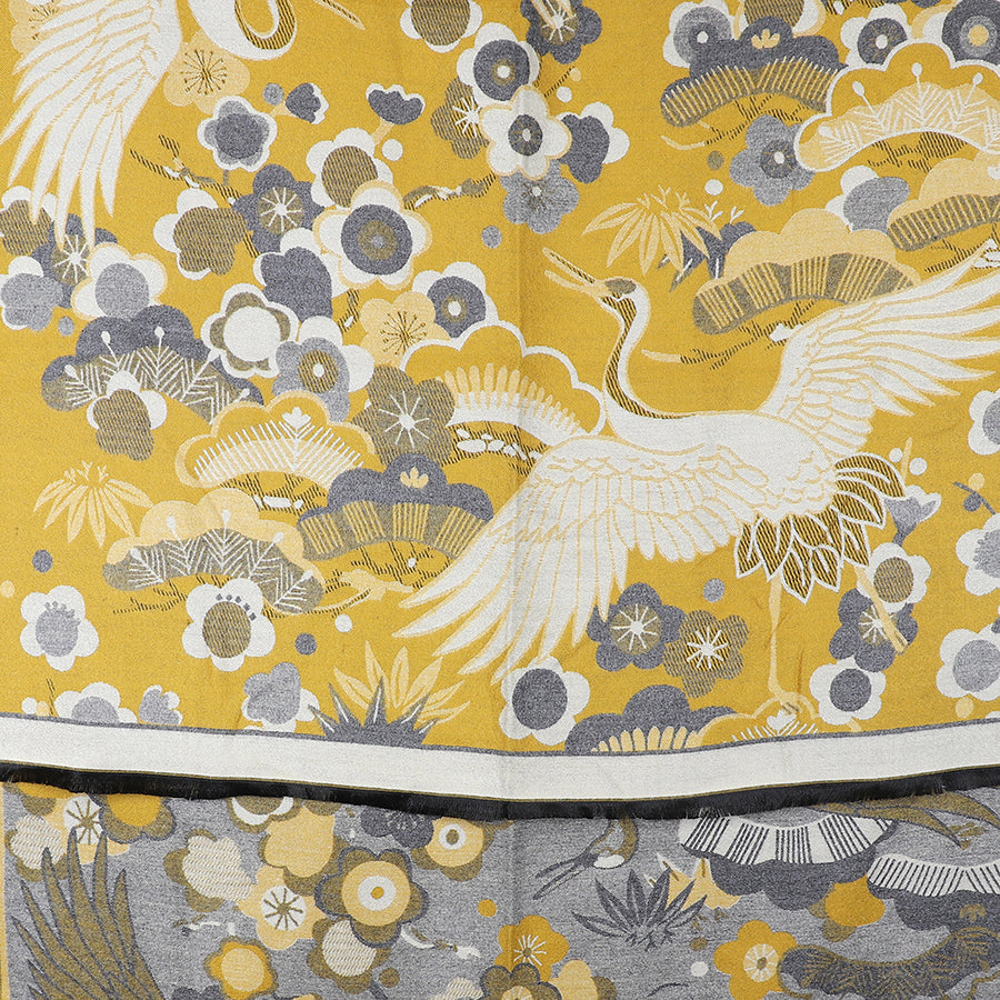 Yellow and grey patterned floral jacquard scarf featuring cranes with outstretched wings amid an arrangement of stylised flowers and leaves.