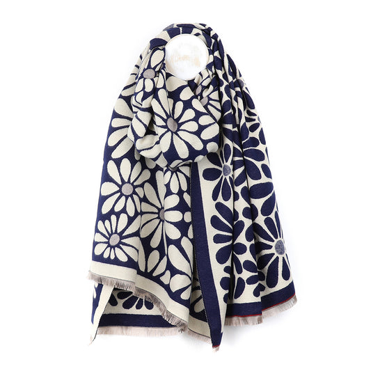 Navy Retro Daisy Scarf in a striking jacquard design, adorned with bold white daisy flowers, gracefully draped over a hook against a pristine white background.