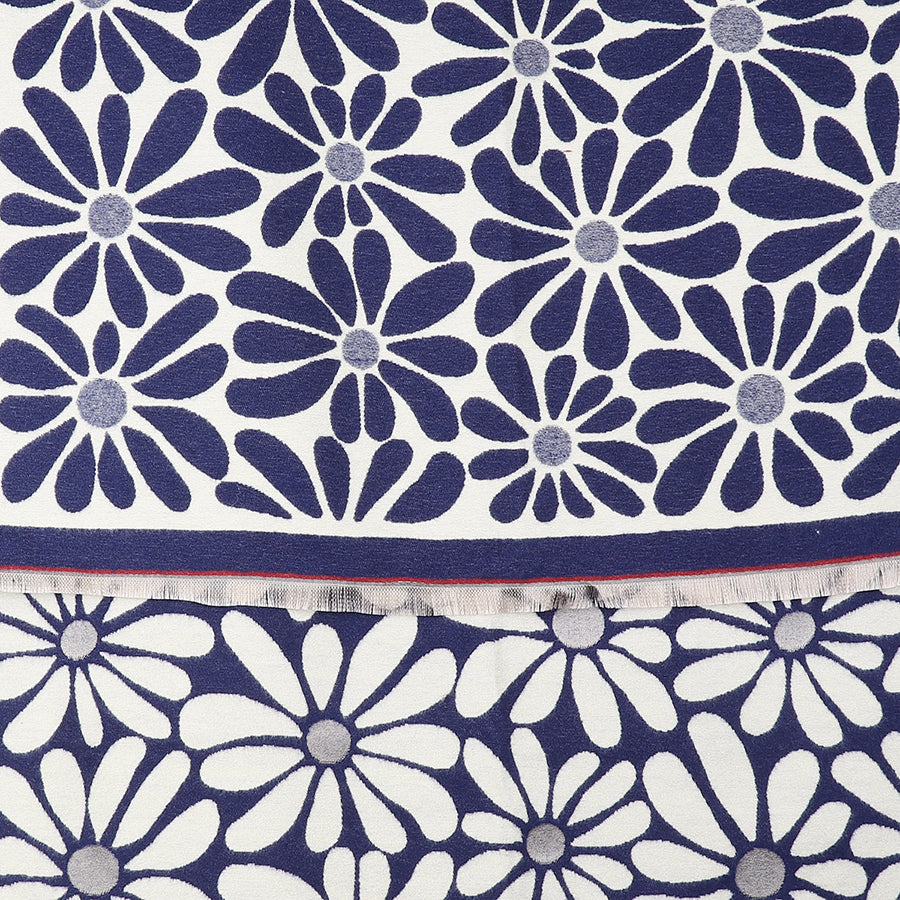 A close-up of fabric displaying a navy blue and white daisy motif, with overlapping floral patterns and a visible edge showing frayed threads—ideal for a Navy Retro Daisy Scarf.