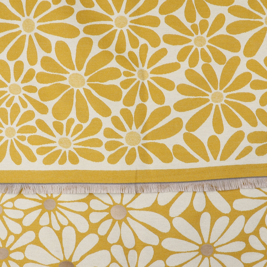 Yellow and white fabric featuring a striking floral daisy pattern and fringed edges, this Yellow Retro Daisy Scarf is laid flat with a section of the fringe clearly visible.