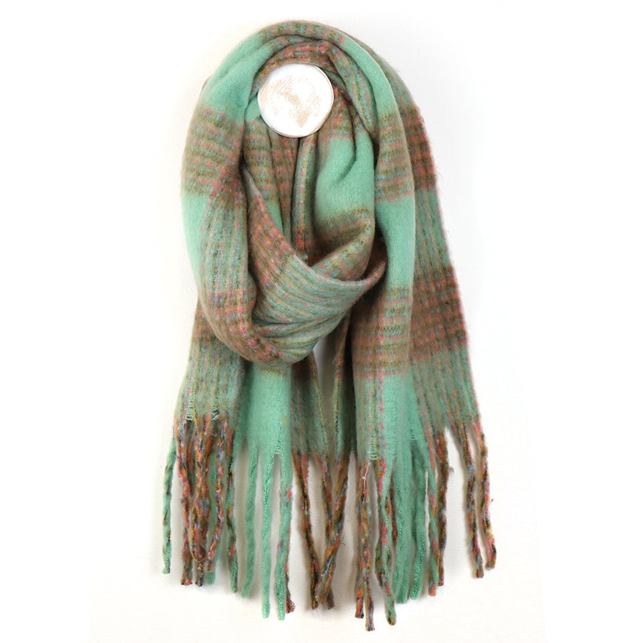 A chunky chequered scarf in green and brown tartan with fringed ends is looped against a plain white background—a perfect accessory for chilly weather.