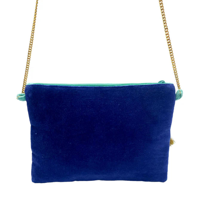 A rectangular blue velvet Glimmer crossbody bag with a gold chain strap and turquoise zip; this vegan-friendly accessory is photographed against a white background—ideal as a Christmas present.