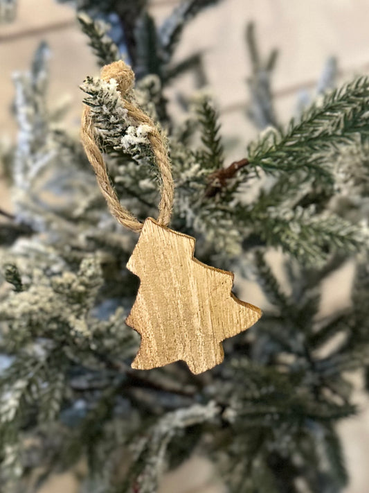 A wooden Christmas tree decoration hangs from a snow-dusted artificial pine branch, bringing a rustic touch to your festive décor.