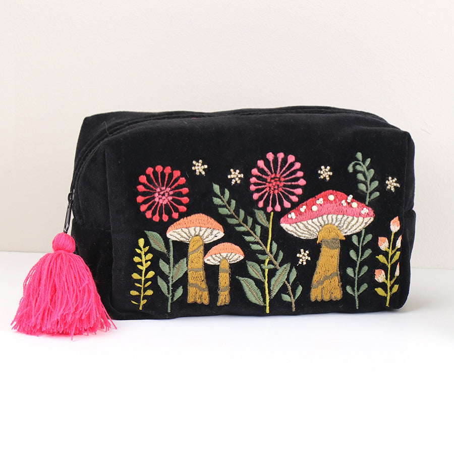 Black velvet bag with colourful embroidered toadstools and flowers, featuring a pink tassel on the zip, perfect for make-up storage.