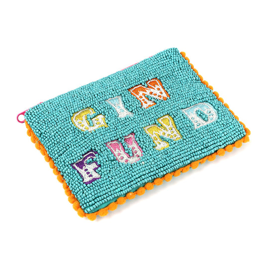 A small aqua beaded purse with vibrant orange pom-pom trim and a playful GIN FUND motif on the front, crafted in colourful, patterned letters.