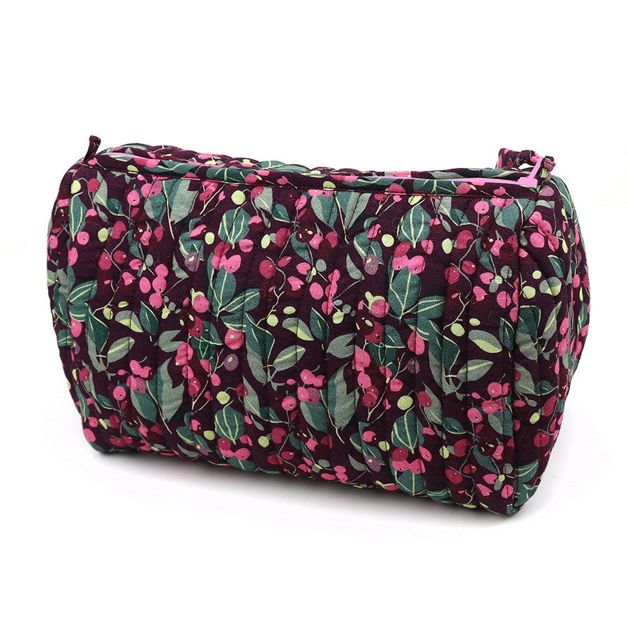 Quilted make-up bag with a zip, set against a dark background and decorated with a floral pattern in green, pink, and red hues—ideal for keeping your beauty essentials.