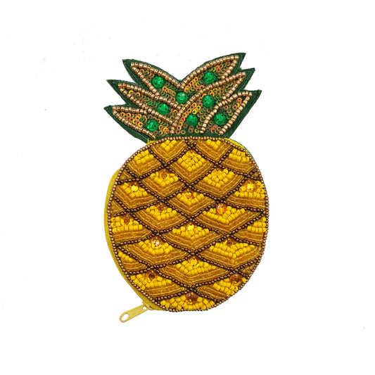 A quirky, pineapple-shaped handbag adorned with beads and sequins, boasting yellow, green, and gold accents on a white background—a perfect vegan-friendly gift for anyone who loves distinctive accessories.