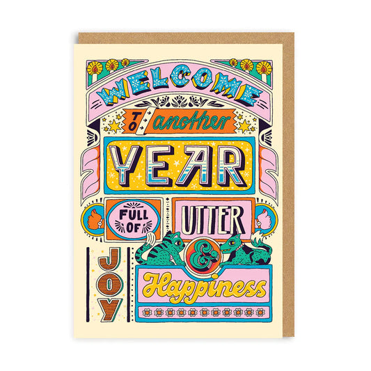 A vibrant greeting card by Frieda Ruh features bold text: Welcome to Another Year Full of Happiness, surrounded by cheerful floral and animal illustrations.