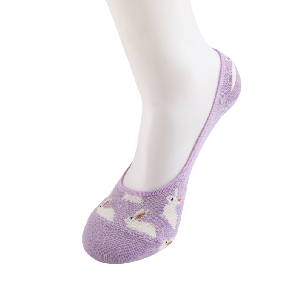 A mannequin foot is shown wearing Miss Sparrow Lilac Rabbits Invisible Footsie Socks—vegan-friendly socks in lavender with white bunny designs, photographed against a white background.