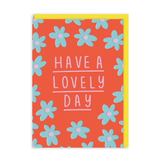 A cheerful daisy design brightens this Have a Lovely Day card, with a red background, blue flowers, and pink lettering. A yellow envelope peeks out from behind, ideal for sending heartfelt wishes.
