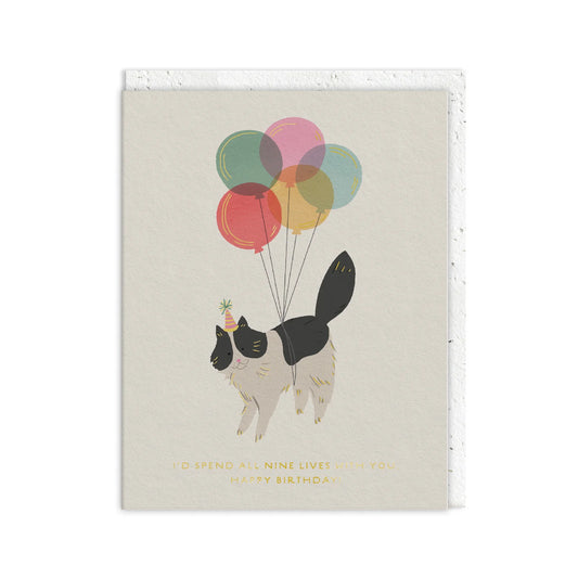 Whimsical greetings card showing a cat in a party hat floating with six colourful balloons, with the text I’d spend all nine lives with you. Happy Birthday. Ideal for cat lovers.