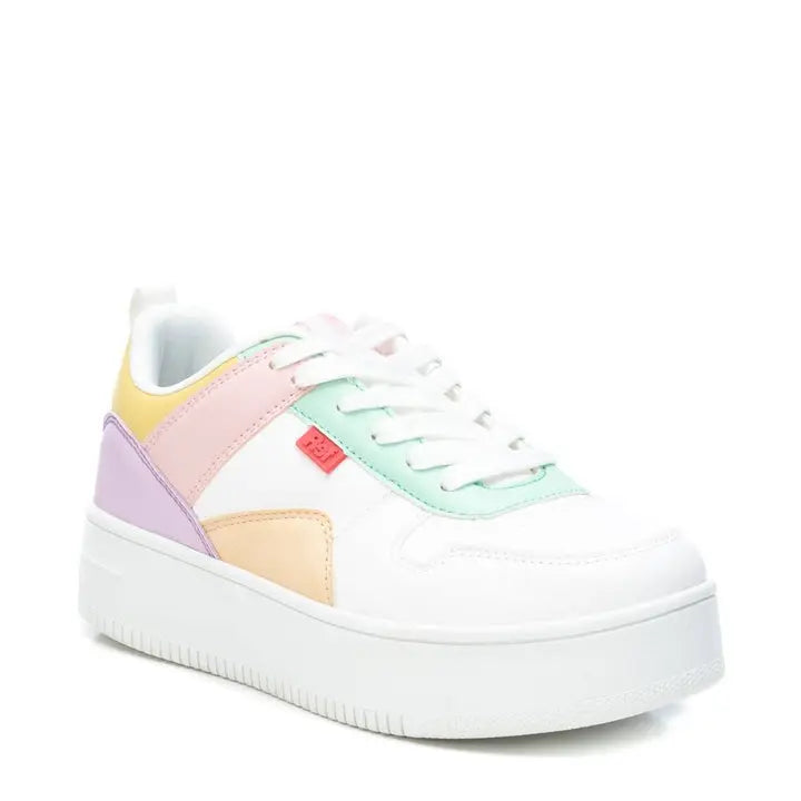 Low-top pastel trainers with a thick rubber platform, featuring sections in pink, green, purple, yellow, and orange. Made from vegan leather and highlighted by a small red tag detail on the side.