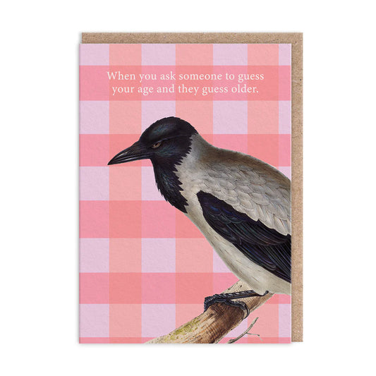 Greeting card featuring a black and grey crow perched on a branch against a pink chequered background. Text reads: When you ask someone to guess your age, and they guess older—as if youre from the Jurassic era.