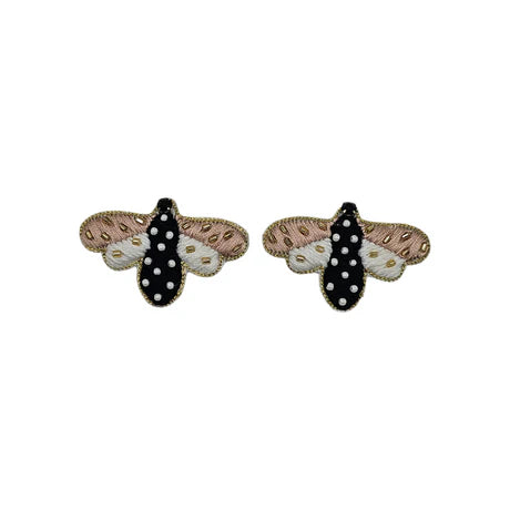 A pair of embroidered moth-shaped patches with black, white, and pink wings, and white polka dots on the black section—perfect for pairing with your favourite stud earrings.