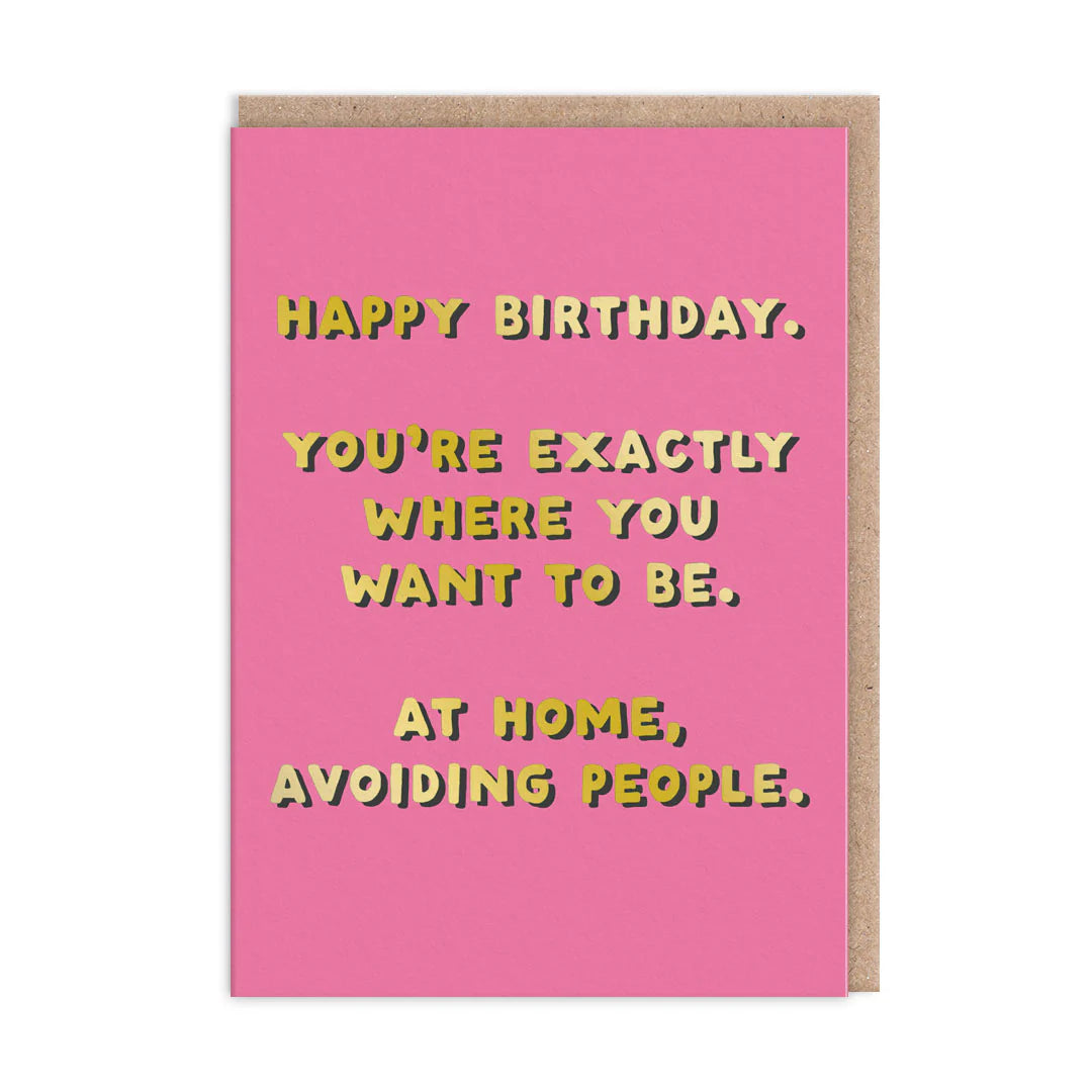 A playful pink birthday card with yellow text reads: Happy Birthday. Youre exactly where you want to be—at home, avoiding people. A humorous message thats perfect for the introvert in your life!.