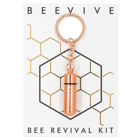 A rose gold keyring labelled BEEVIVE is attached to a card featuring a honeycomb design and the text BEE REVIVAL KIT, perfect for supporting an eco-conscious lifestyle.