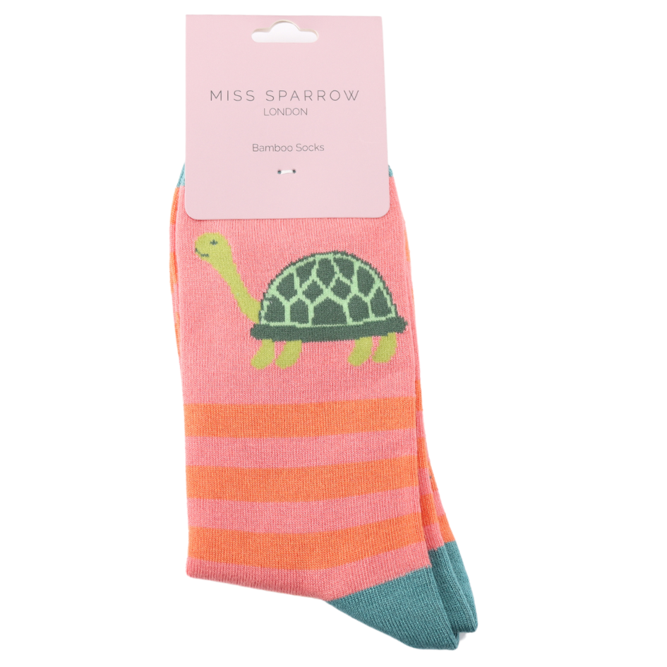 A pair of pink and orange striped bamboo and cotton socks with a green turtle design, featuring a turtle and stripe motif, packaged and labelled Miss Sparrow London Vegan Socks.