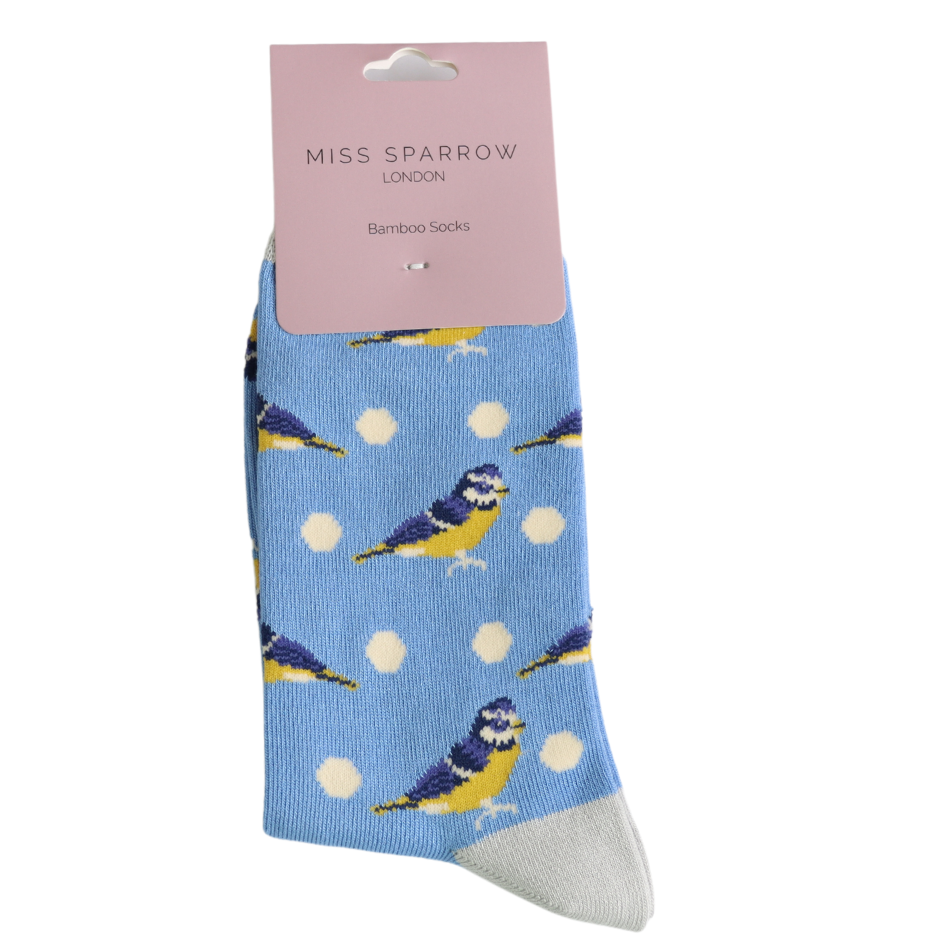 A pair of vegan-friendly cornflower socks featuring yellow and blue bird and white polka dot patterns, labelled Miss Sparrow London Bamboo Socks on a pink tag.