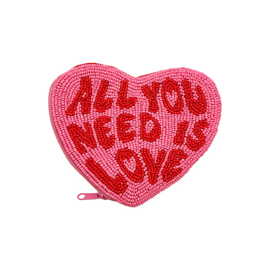 A pink, Beatles heart-shaped purse with red beaded lettering that reads ALL YOU NEED IS LOVE and a zip on the left side—ideal as a music-inspired accessory.