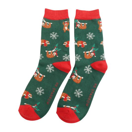 A pair of green festive socks with red heels and cuffs, featuring a playful sloth motif in Santa hats, snowflakes, and the wording MR SPARROW on the soles.