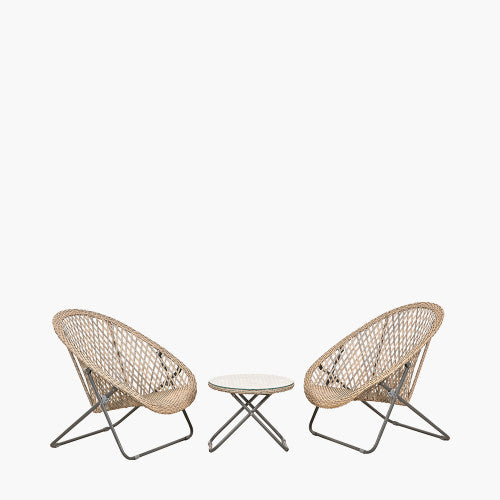 Two round rattan chairs with metal legs are positioned on either side of a small round wicker table with a glass top, creating a stylish garden furniture set against a plain white background.